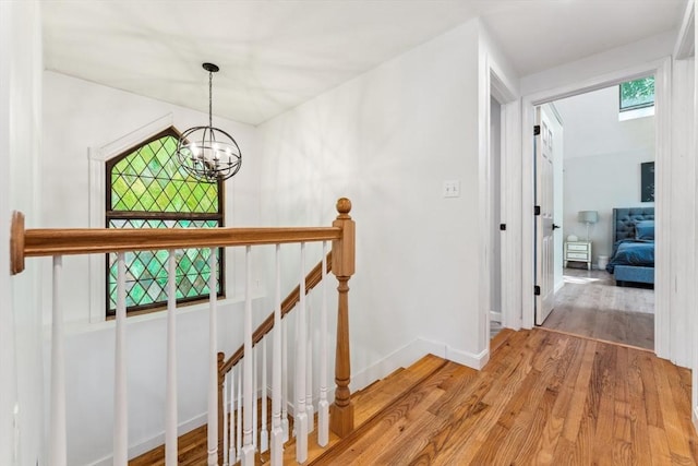 17 Atwood Ave, Millbury, MA 01527 - hall with an upstairs landing, light wood-style flooring, a chandelier, and baseboards