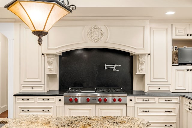 kitchen featuring decorative backsplash, premium range hood, stainless steel gas stovetop, and dark stone counters