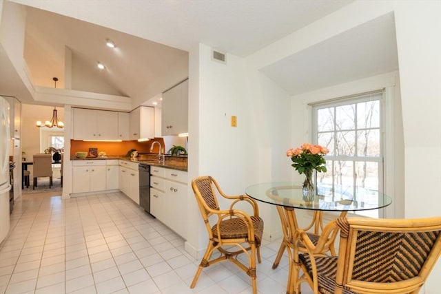 kitchen featuring light tile patterned flooring, lofted ceiling, white cabinetry, dishwasher, and a notable chandelier