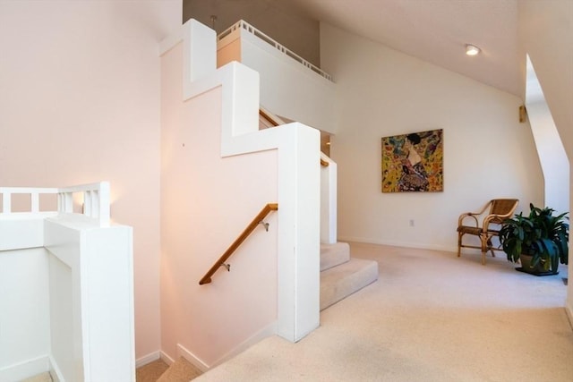 staircase with high vaulted ceiling and carpet