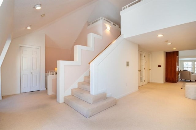 stairs featuring vaulted ceiling and carpet