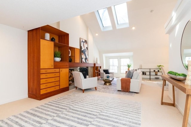 sitting room with light colored carpet, a skylight, and high vaulted ceiling