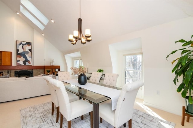 dining area featuring an inviting chandelier, a skylight, and high vaulted ceiling