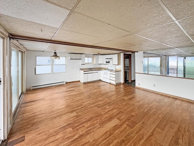 498 N End Blvd, Salisbury, MA 01952 - unfurnished living room with a baseboard heating unit, wood finished floors, and a drop ceiling