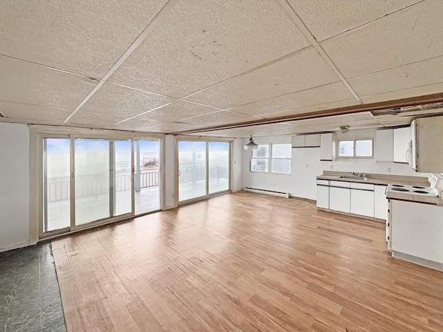 498 N End Blvd, Salisbury, MA 01952 - unfurnished living room featuring baseboard heating, light wood-style flooring, and a paneled ceiling