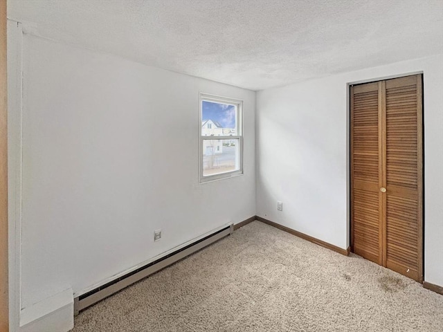 498 N End Blvd, Salisbury, MA 01952 - unfurnished bedroom with a baseboard radiator, carpet floors, a closet, and a textured ceiling