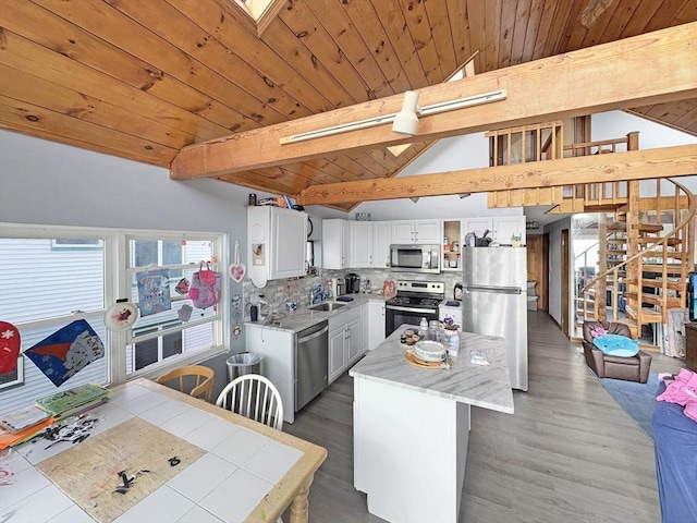 498 N End Blvd, Salisbury, MA 01952 - kitchen with stainless steel appliances, a center island, white cabinets, decorative backsplash, and plenty of natural light