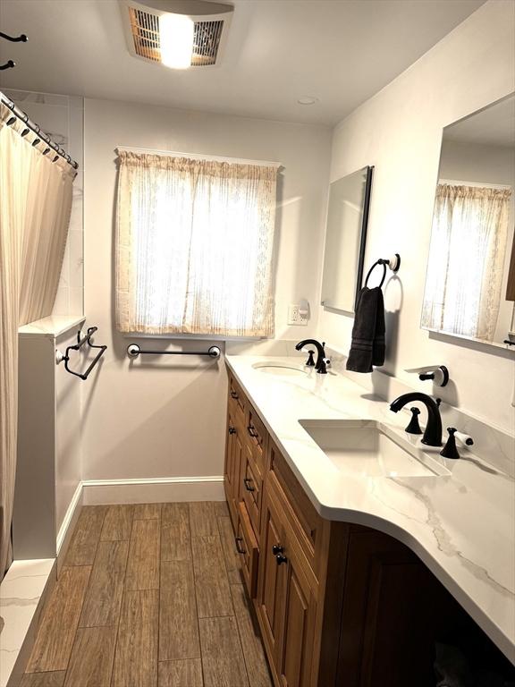 bathroom featuring hardwood / wood-style flooring, vanity, and a healthy amount of sunlight