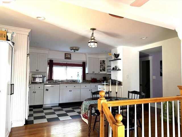 kitchen with dishwasher, white cabinets, pendant lighting, and sink