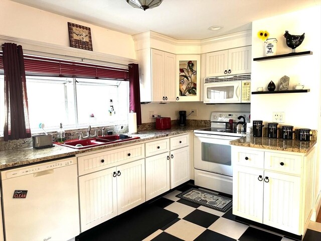 kitchen featuring white appliances, sink, and cream cabinets