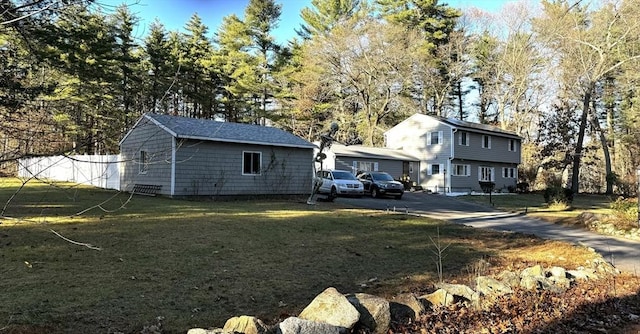 back of property with a lawn and an outdoor structure