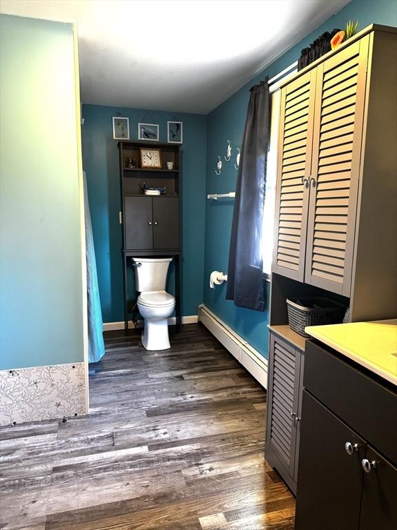 bathroom with vanity, a baseboard radiator, toilet, and hardwood / wood-style flooring