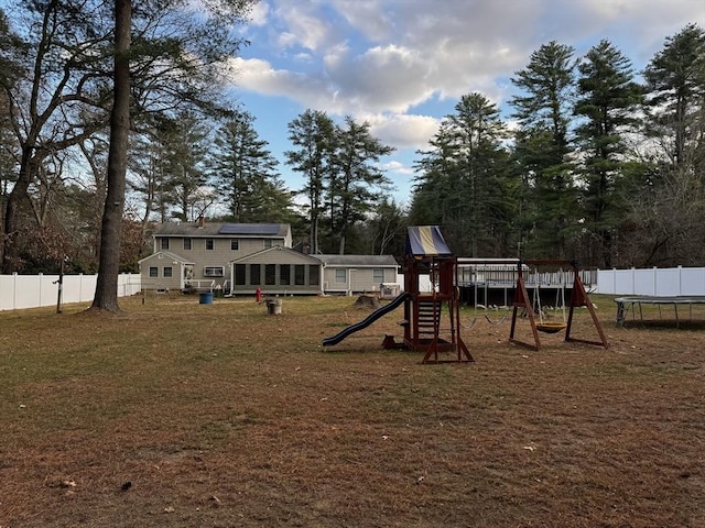 view of play area featuring a trampoline and a lawn