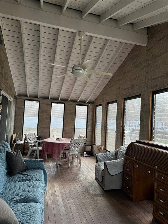 sunroom with lofted ceiling with beams, ceiling fan, and wood ceiling