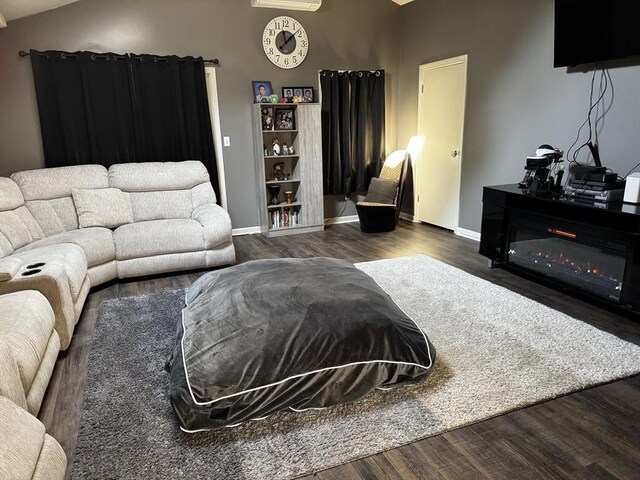 living room featuring dark hardwood / wood-style flooring and vaulted ceiling