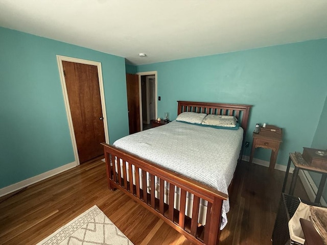 bedroom featuring a closet, baseboards, and wood finished floors