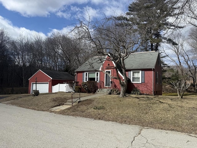 view of front of home with a garage, an outbuilding, and a shingled roof