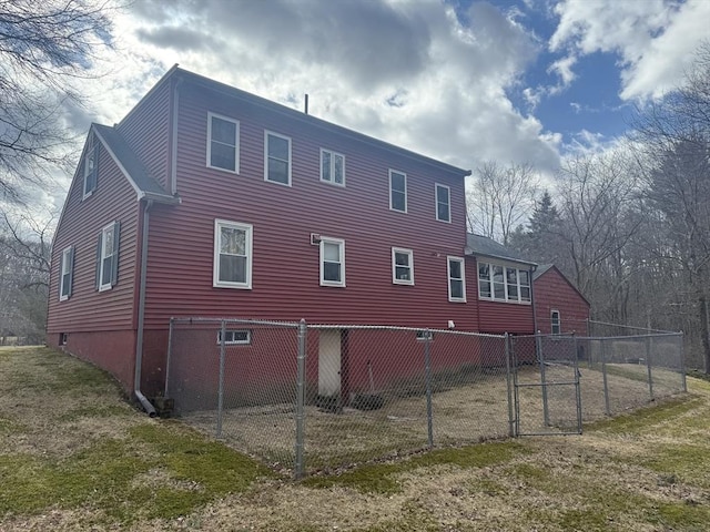 back of house with a lawn and fence