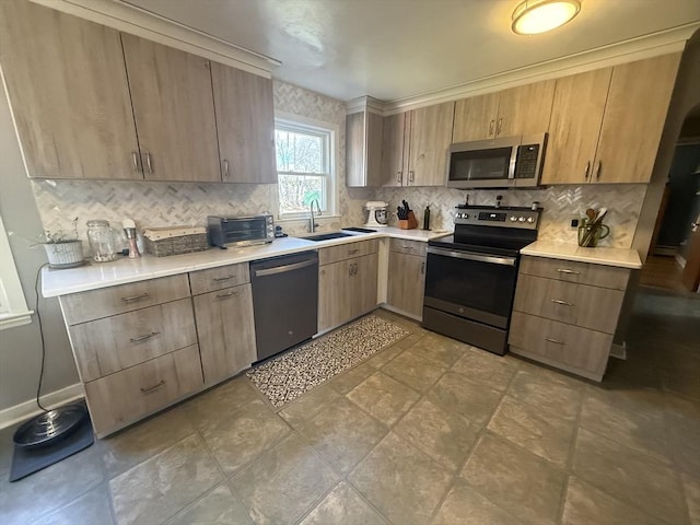 kitchen with a toaster, a sink, stainless steel appliances, light countertops, and tasteful backsplash