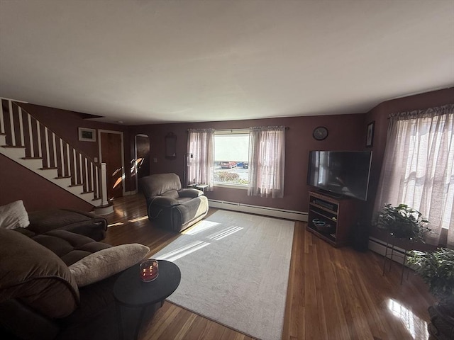 living room with a baseboard radiator, wood finished floors, and stairway