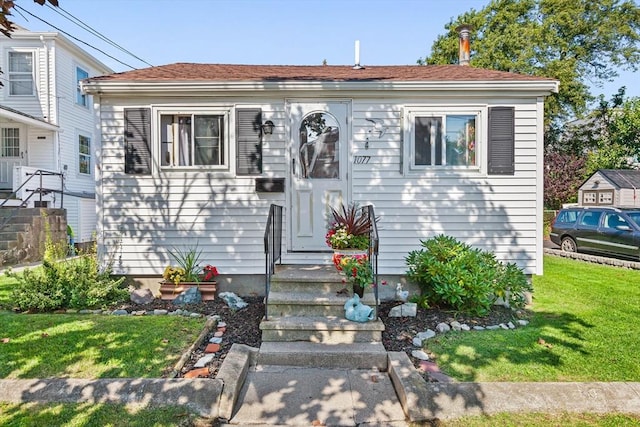 bungalow-style house featuring a front lawn