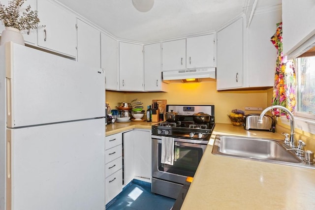 kitchen featuring freestanding refrigerator, light countertops, under cabinet range hood, and gas stove