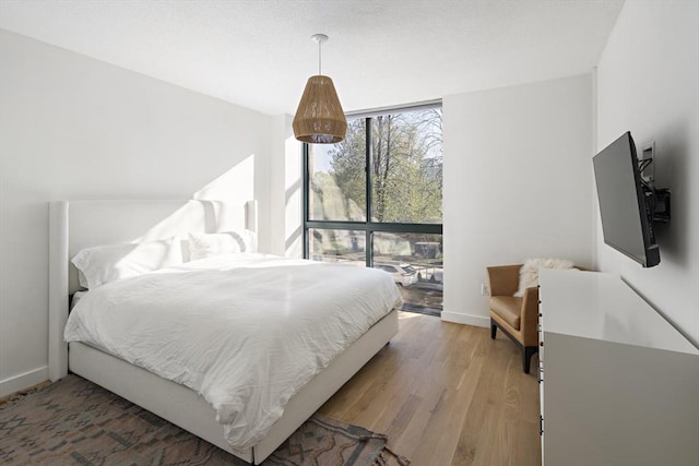 bedroom featuring baseboards and light wood finished floors