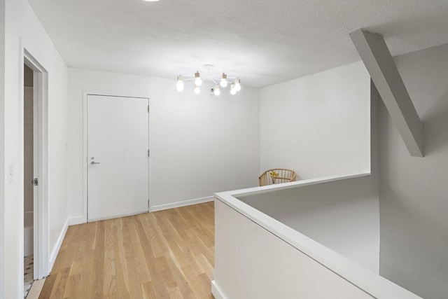 hallway featuring baseboards and light wood finished floors