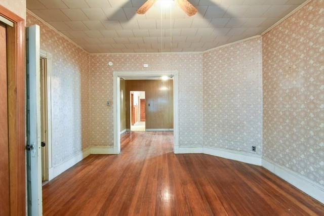 spare room featuring crown molding, hardwood / wood-style floors, and a ceiling fan