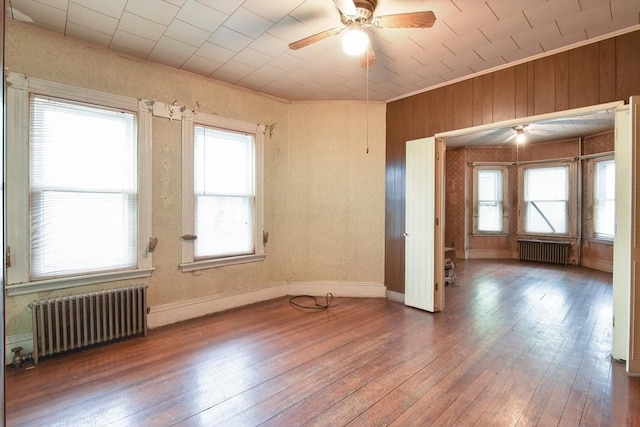 unfurnished room with a ceiling fan, radiator heating unit, and wood-type flooring