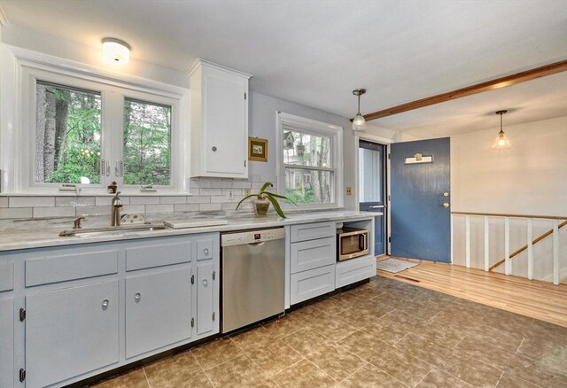kitchen with stainless steel appliances, a sink, light countertops, and tasteful backsplash