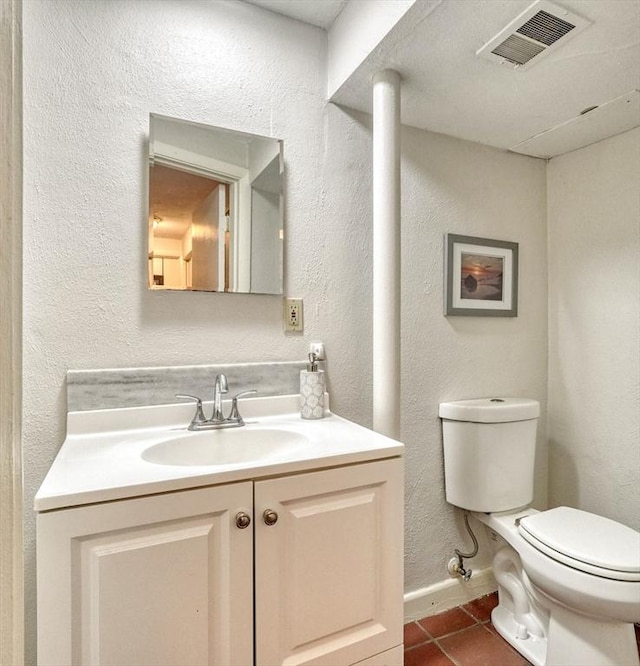 half bathroom with tile patterned floors, toilet, vanity, and baseboards