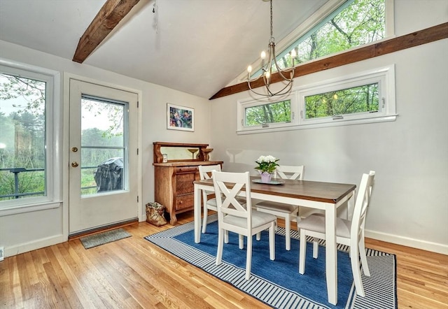 dining room featuring healthy amount of natural light, light wood-style flooring, and a chandelier