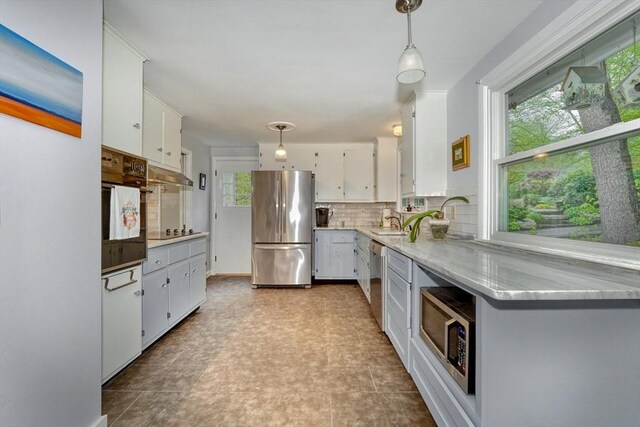 kitchen with black appliances, backsplash, white cabinets, and pendant lighting