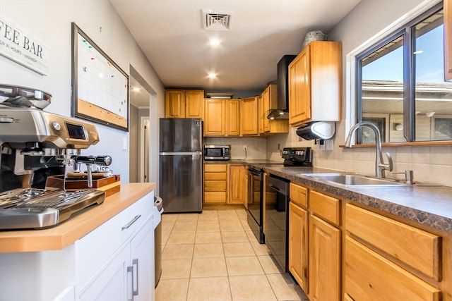 kitchen with black appliances, wall chimney range hood, sink, decorative backsplash, and light tile patterned floors