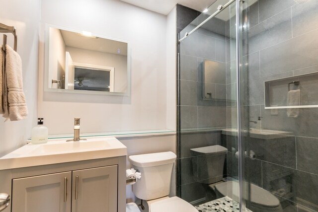 bathroom featuring vanity, toilet, and walk in shower