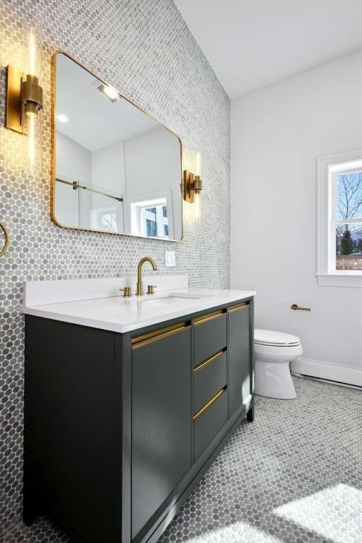 full bathroom with tasteful backsplash, a shower with shower door, tile walls, toilet, and vanity