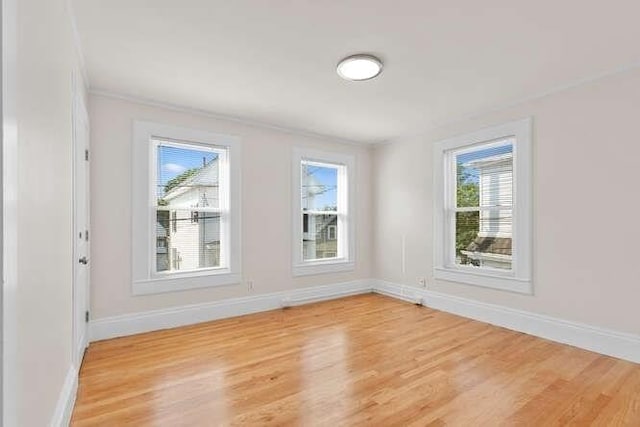 9 Foster St Unit 2, Gloucester, MA 01930 - spare room with plenty of natural light, light wood-type flooring, and ornamental molding