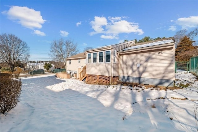 view of snow covered back of property