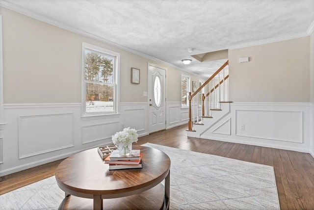 foyer with ornamental molding, a textured ceiling, and dark hardwood / wood-style flooring