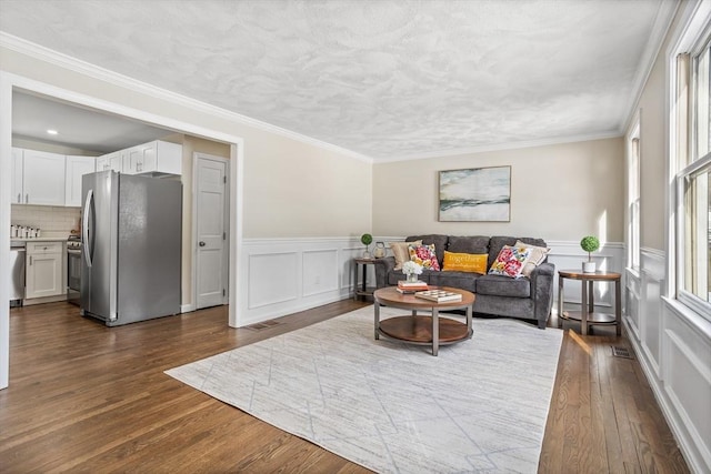 living room featuring dark wood-type flooring and ornamental molding