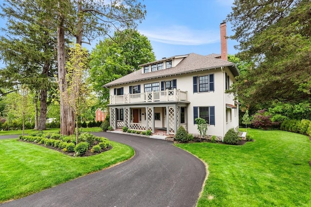 2 Percy Rd, Lexington, MA 02421 - view of front facade with a balcony, a chimney, stucco siding, and a front lawn