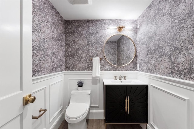 2 Percy Rd, Lexington, MA 02421 - bathroom with wallpapered walls, wainscoting, vanity, toilet, and wood finished floors