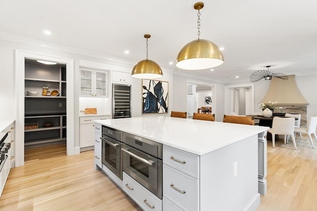 2 Percy Rd, Lexington, MA 02421 - kitchen featuring stainless steel oven, white cabinetry, wine cooler, light countertops, and crown molding