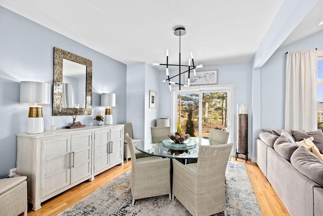 dining room with light wood-style floors and an inviting chandelier