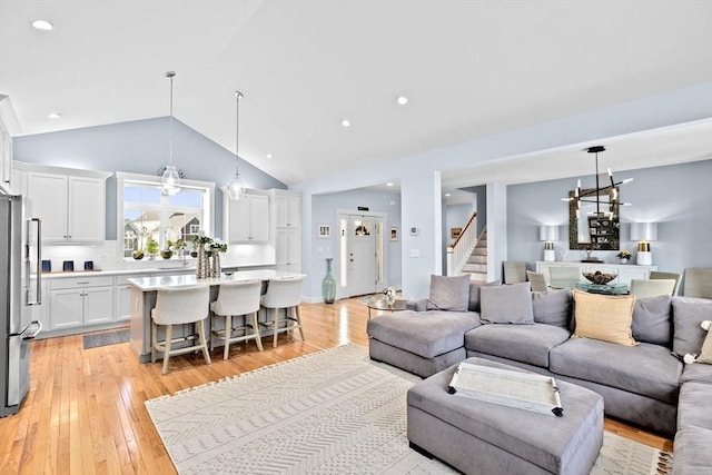 living room featuring light wood-type flooring, stairway, an inviting chandelier, and recessed lighting