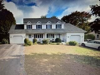 cape cod home featuring a garage