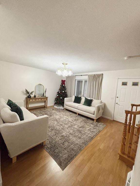 living room with a chandelier, a textured ceiling, and hardwood / wood-style flooring