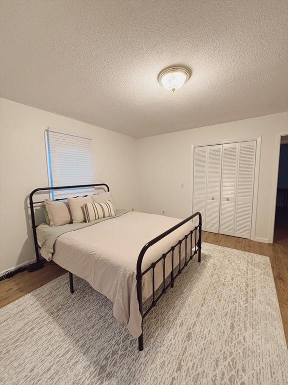 bedroom with hardwood / wood-style floors and a textured ceiling