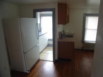 kitchen featuring dark hardwood / wood-style floors, white refrigerator, sink, and radiator